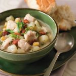 catfish chowder in green bowl with side of bread