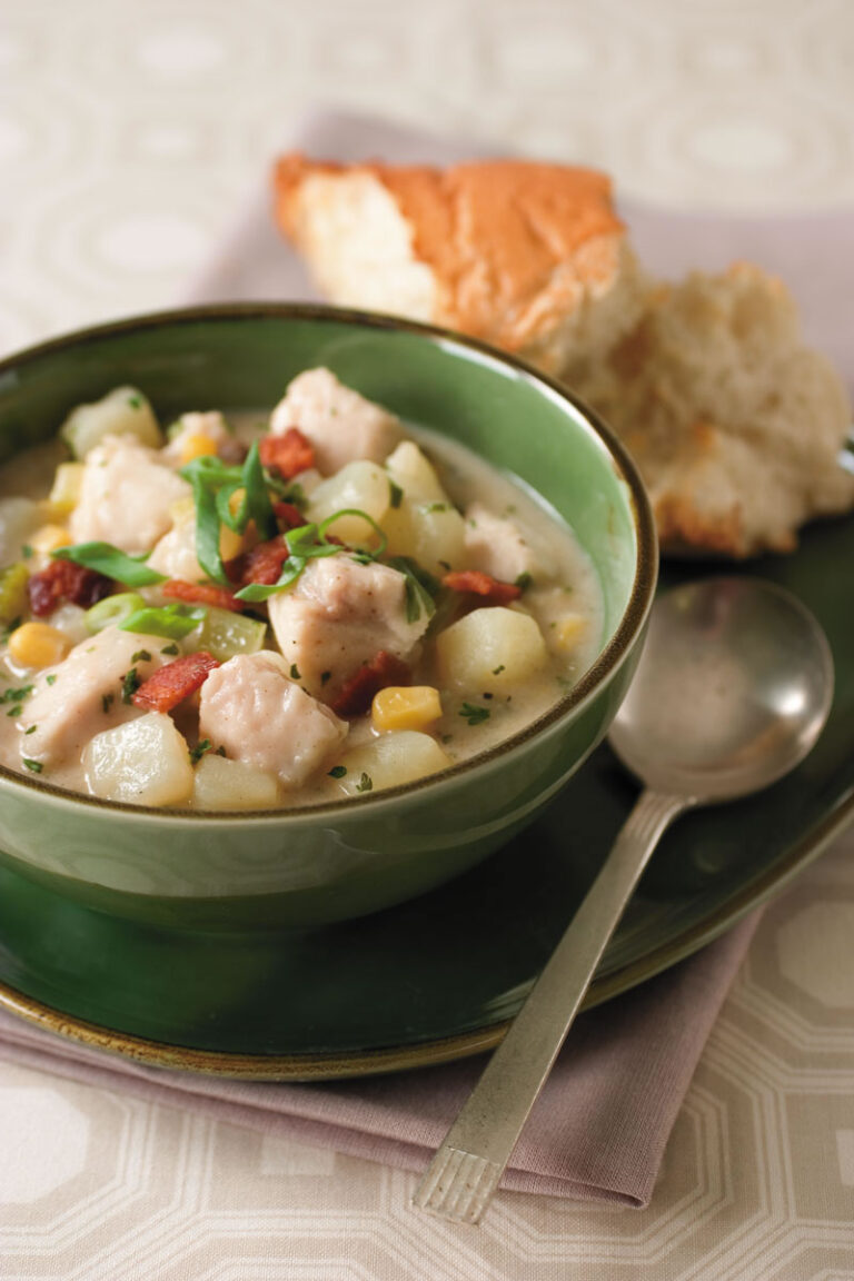 catfish chowder in green bowl with side of bread