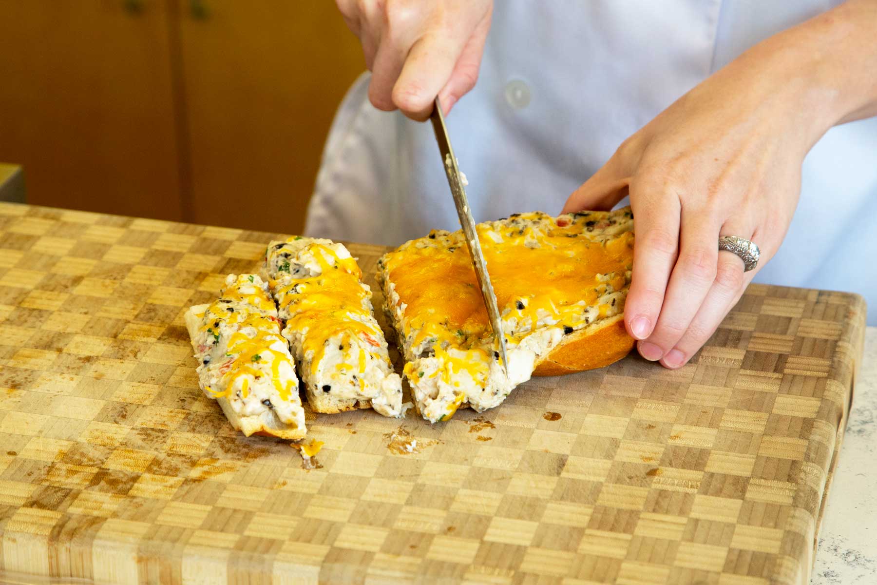 Slicing cheesy catfish bread