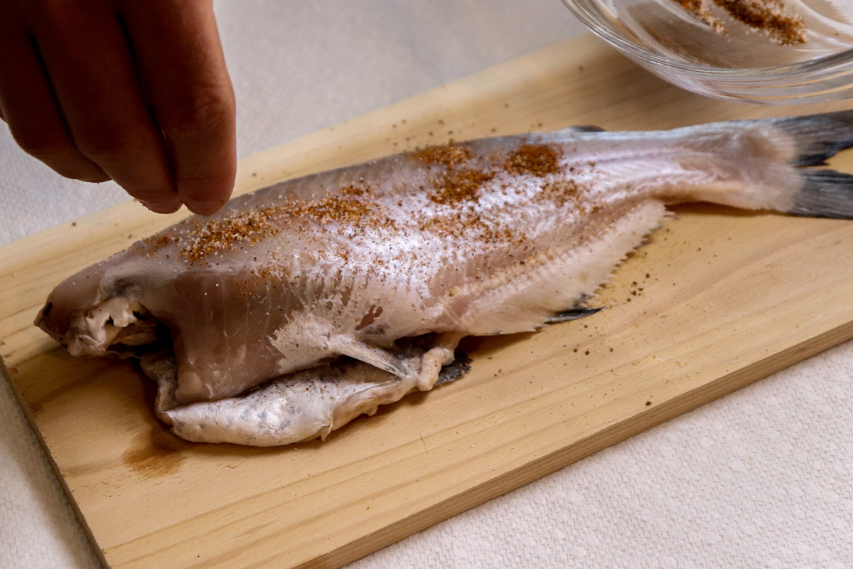 Whole Catfish with seasoning on a cedar plank