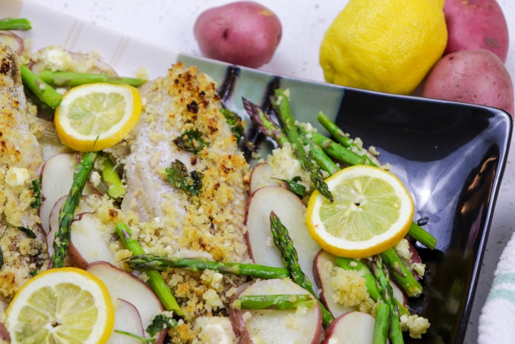 Baked catfish with red potatoes and asparagus on plate