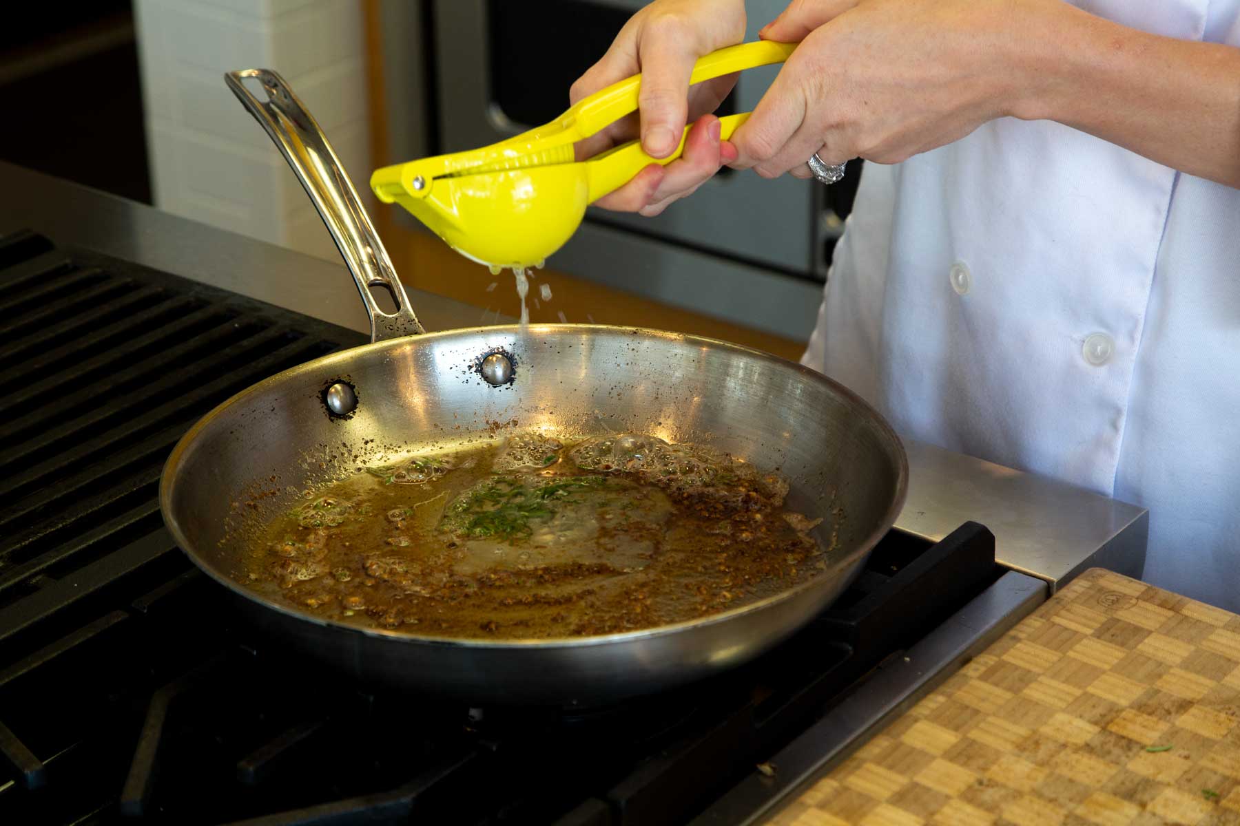 Squeezing lemon into pan on stove