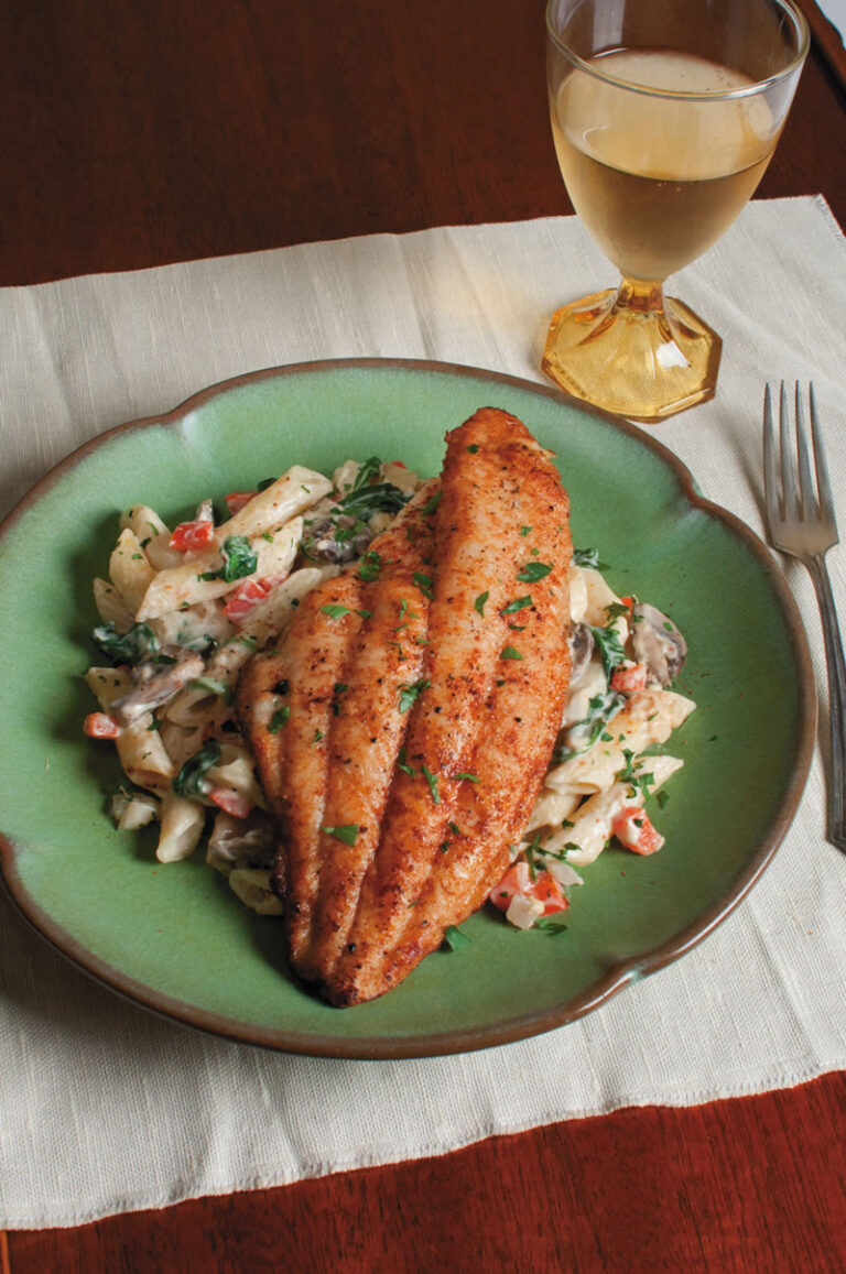 Alfredo pasta topped with cajun season catfish
