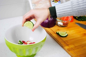 Adding lime to ingredients in bowl
