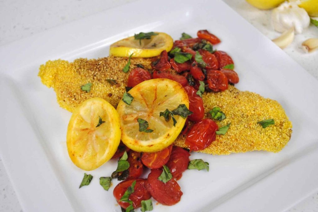 Grits Crusted Catfish topped with tomatoes and lemon