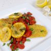 Grits Crusted Catfish topped with tomatoes and lemons
