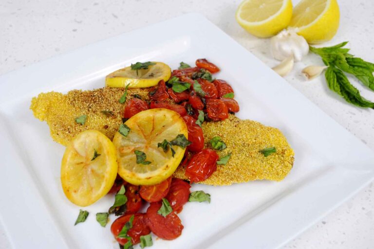 Grits Crusted Catfish topped with tomatoes and lemons