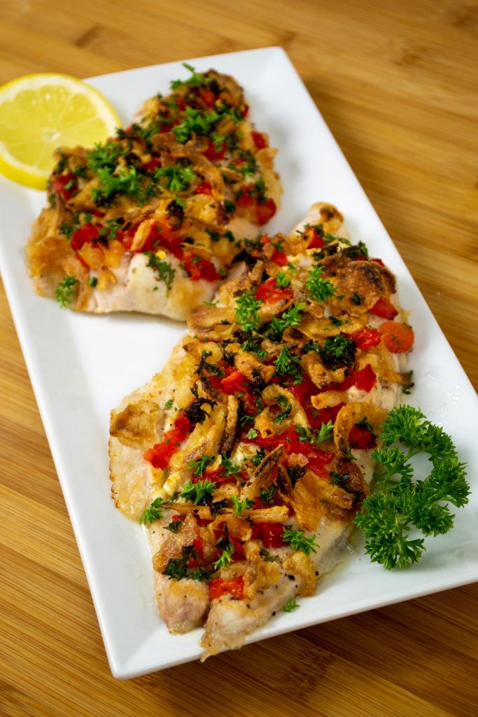 roasted catfish fillets with fresh toppings on plate