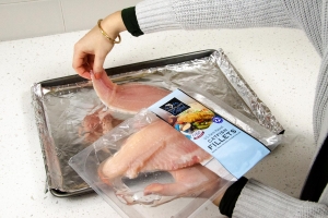 placing catfish fillets on greased baking sheet
