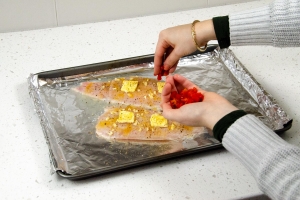 seasoning catfish on baking sheet