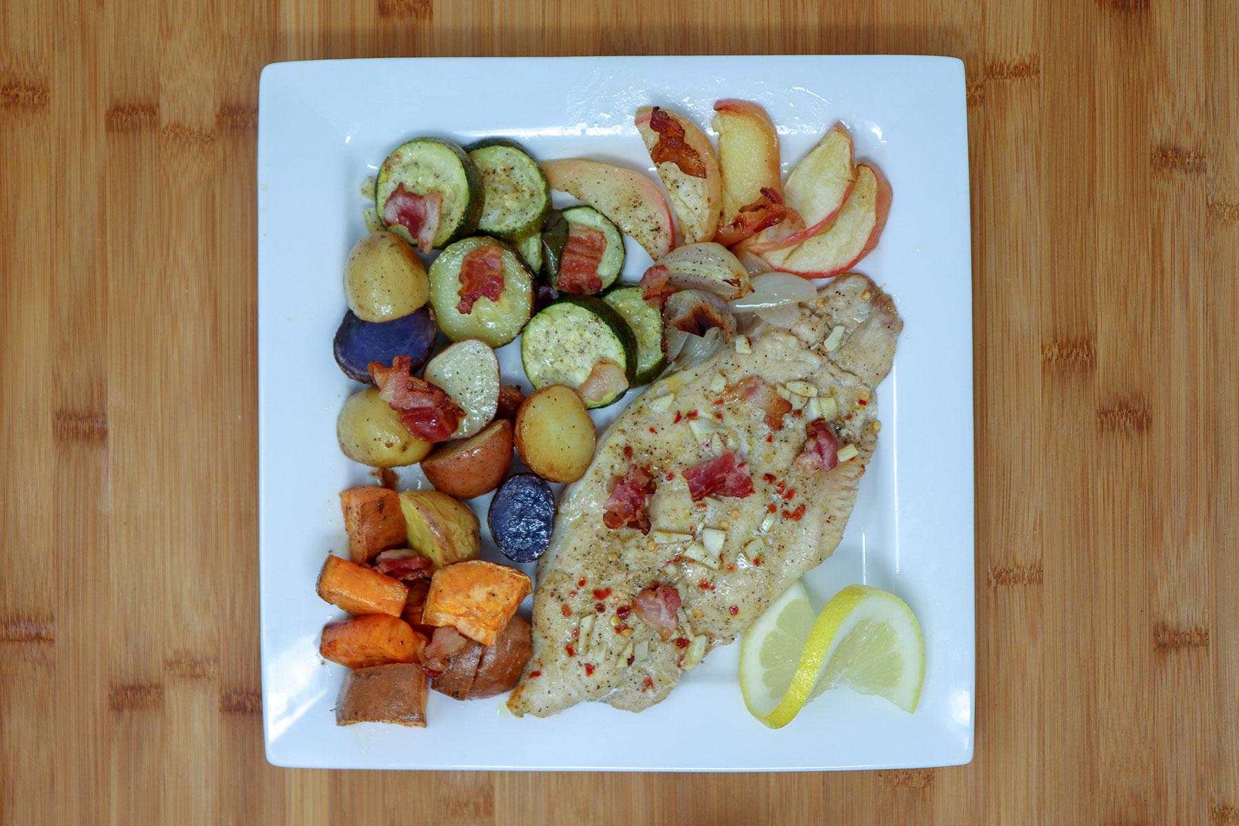 finished sheet pan catfish and veggies on plate