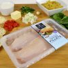 Catfish fillets in packaging surrounded by cooking ingredients