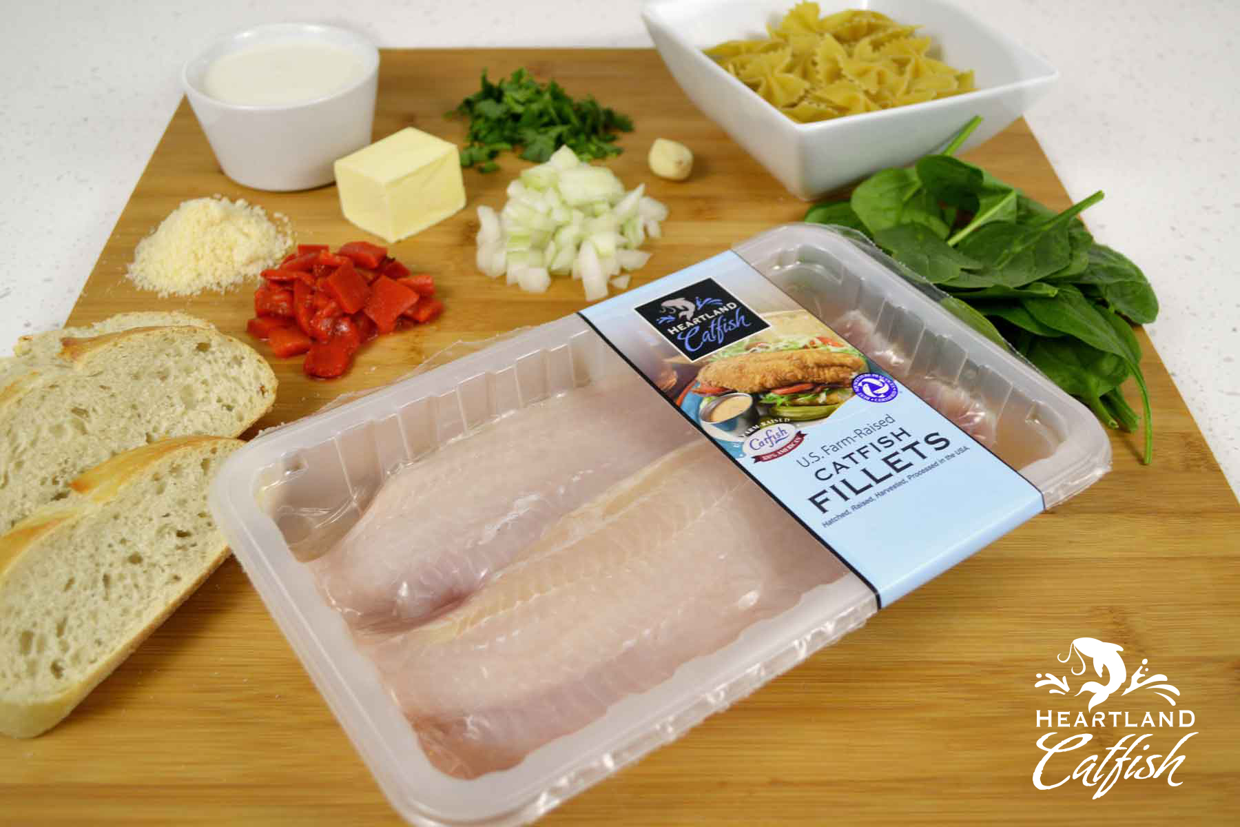 Catfish fillets in packaging surrounded by cooking ingredients