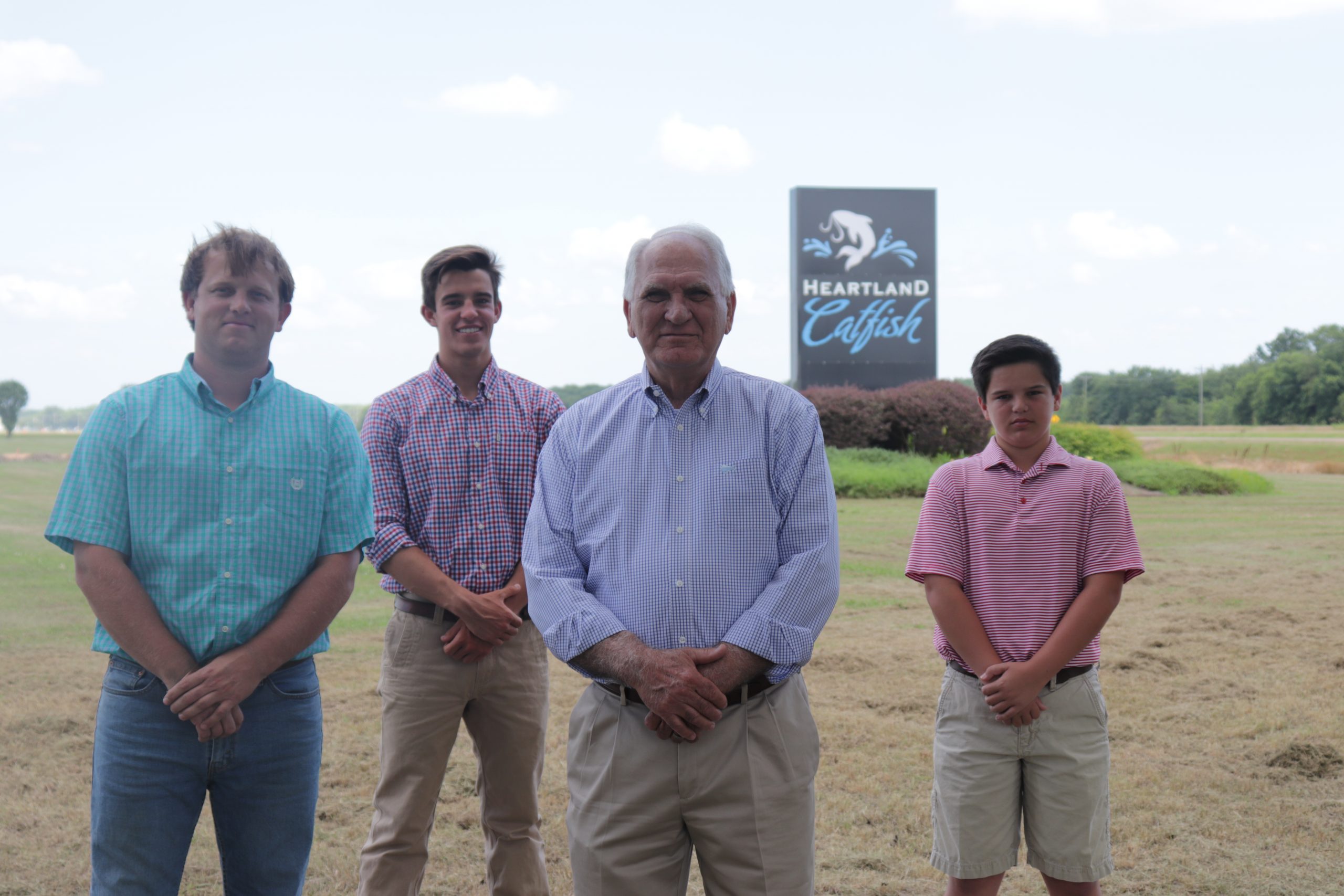 Four generations of Tackett family standing in front of Heartland Catfish sign