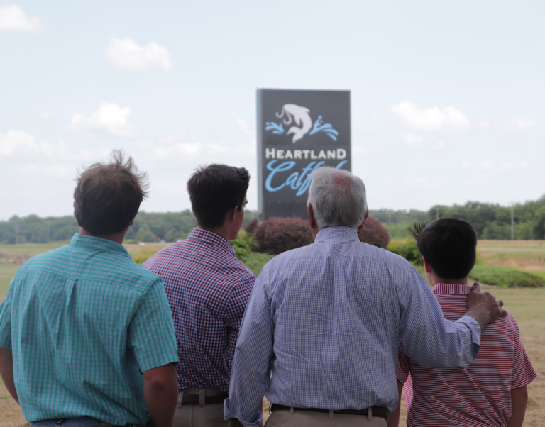 Four generations of Tackett family facing Heartland Catfish sign