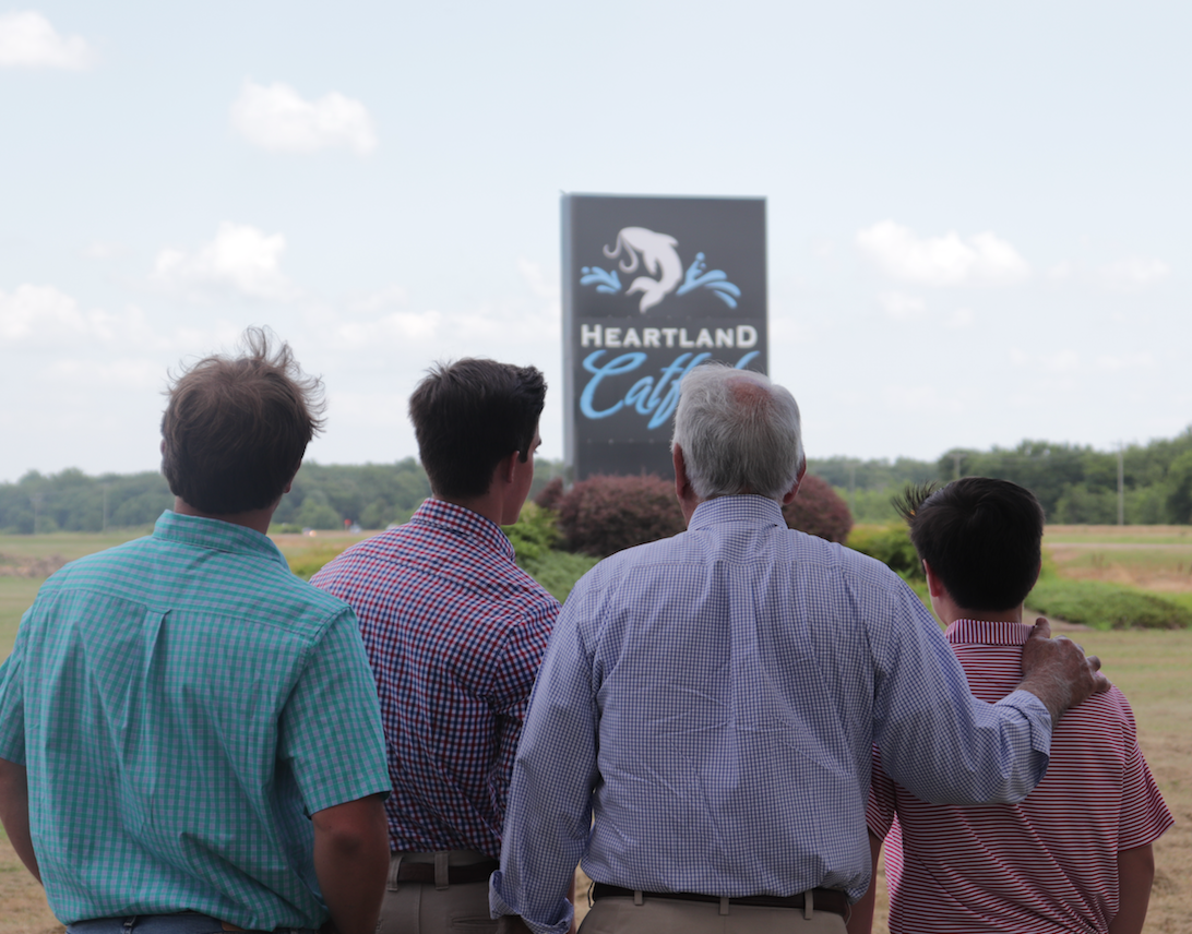 Four generations of Tackett family facing Heartland Catfish sign