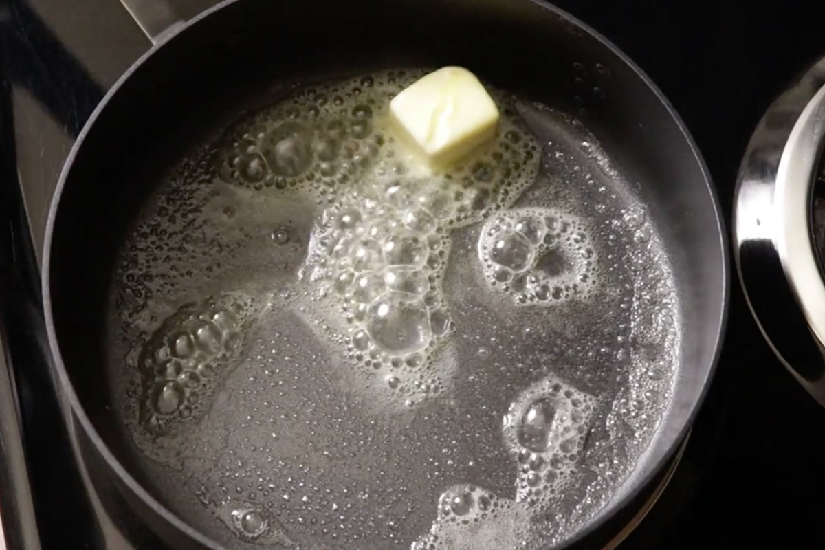 melting butter on stove in cast iron pan