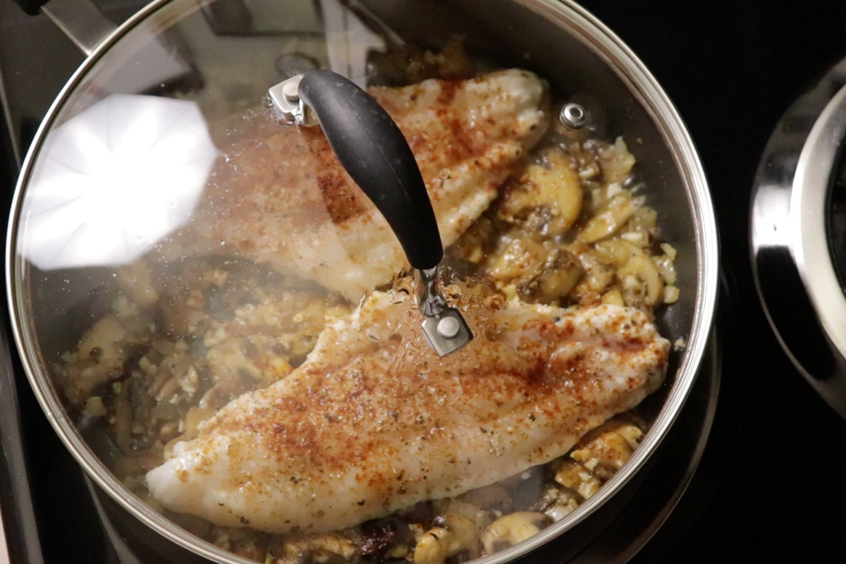 steaming catfish and mushrooms on stove