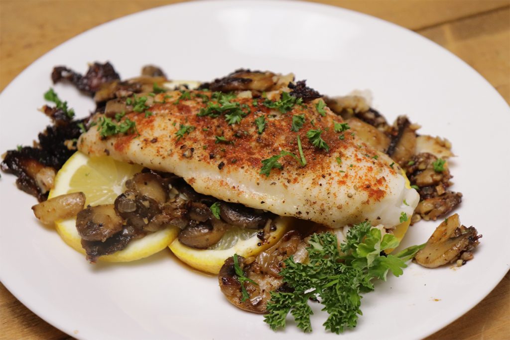 plated lemon pepper catfish on bed of mushrooms